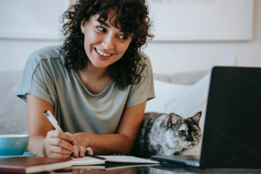 happy woman writing notes from a computer