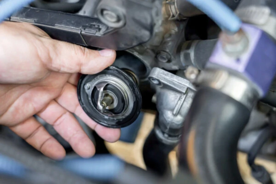 Mechanic holding a car thermostat