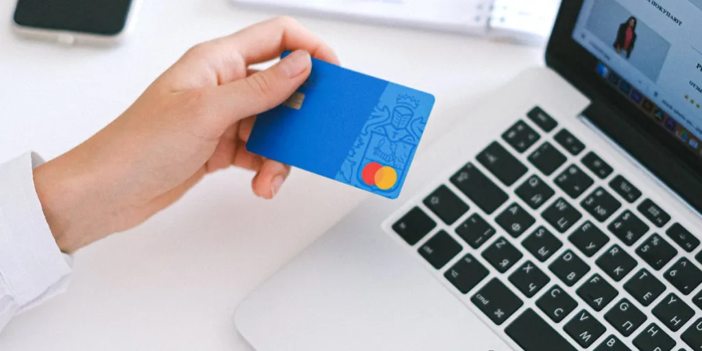 Person making an online purchase on a Mac using their credit card