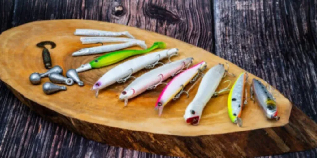Selection of fishing lures laid out on piece of wood