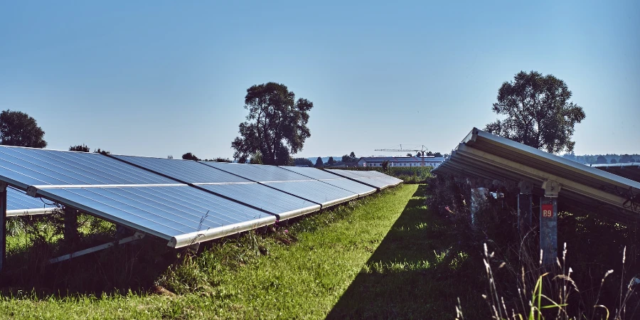 Solar panels on green grass field under blue sky