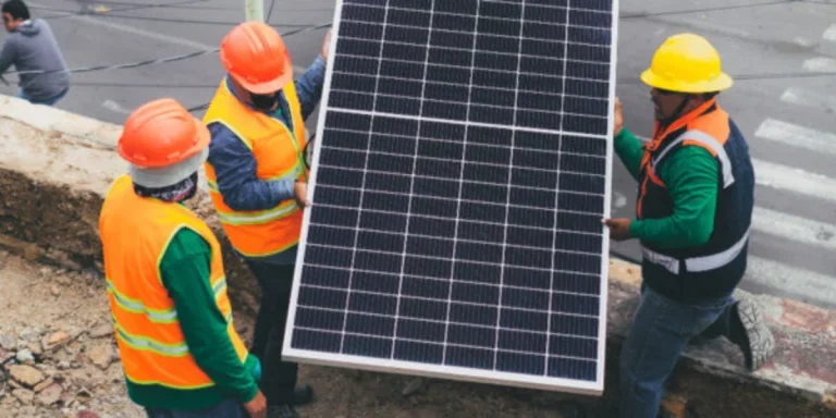 Solar technicians carrying solar panel