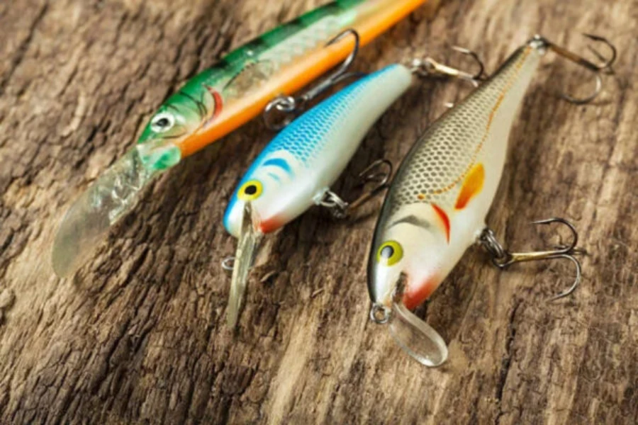 Three different colored heavy sinking minnows laid on wood