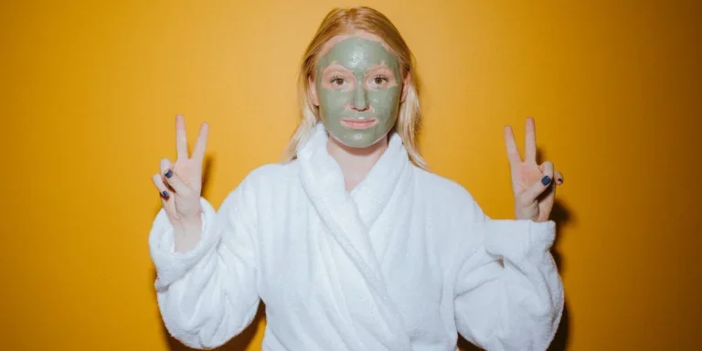 Woman in white bathrobe posing wearing a face mask