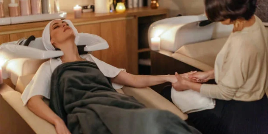 Woman with head in shampoo chair getting hand massage