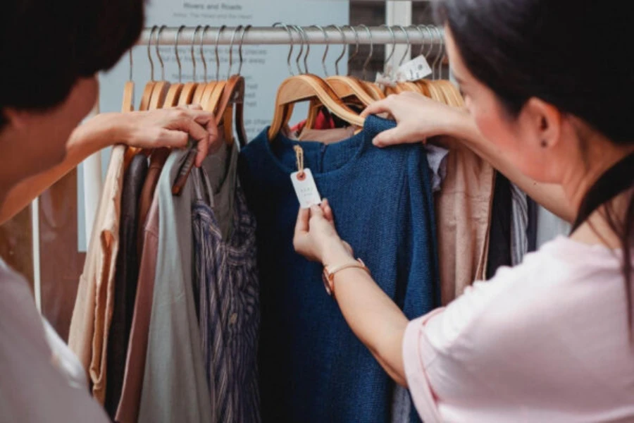 Wanita berbelanja gaun di rak pakaian
