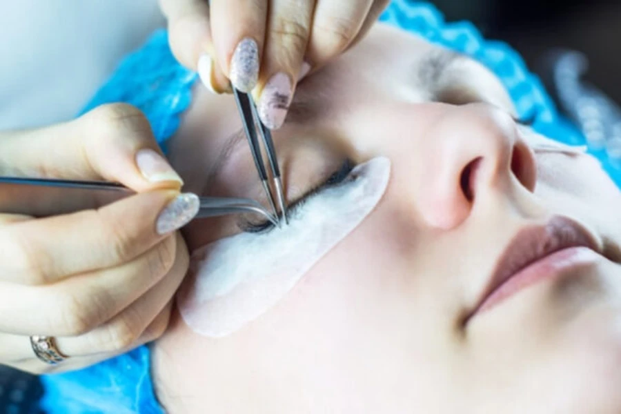 Young woman undergoing eyelash extensions procedure