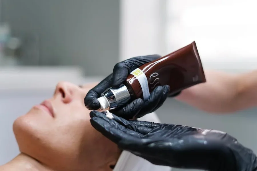 Eine Person trägt Hautcreme auf das Gesicht einer anderen Person auf