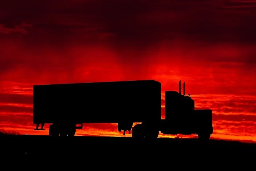 Un camión de transporte que viaja durante la puesta de sol.