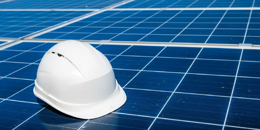 A white hard hat sitting on top of a solar panel