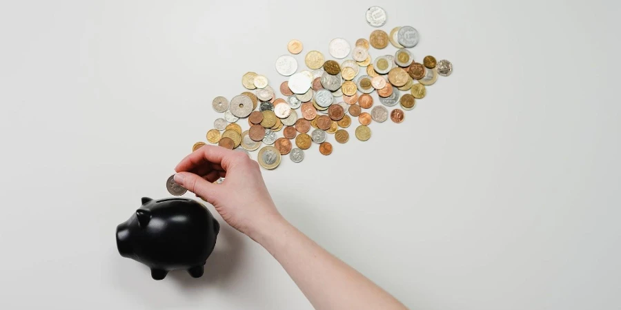 A woman putting coins inside a black piggy bank