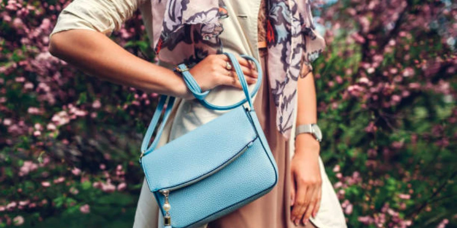 A woman standing outside with a pastel blue purse