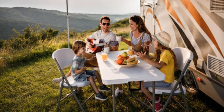 Family sitting at table outside their large camper van