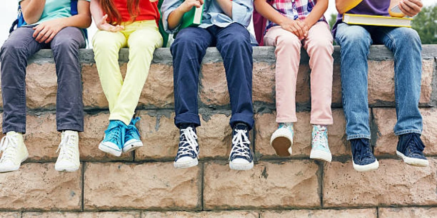 Kids on a brick wall wearing different shoes