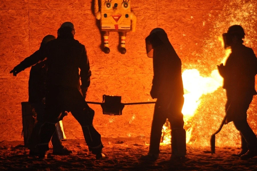 Silhouette de quatre personnes travaillant dans une usine métallurgique