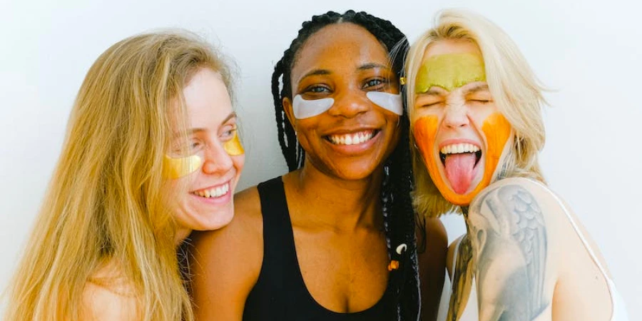 Three women standing together with skincare products on their faces