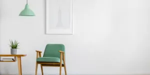 White wall with teal chair and ceiling light