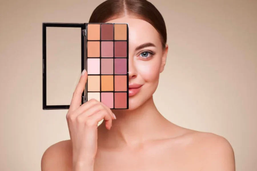 Woman holding up a natural-toned eyeshadow palette