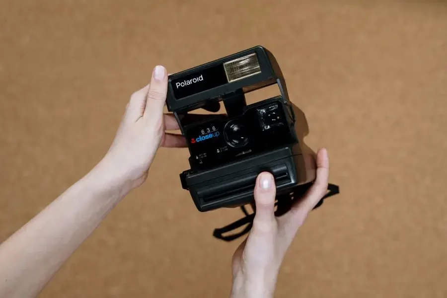 A person holding a Polaroid instant camera