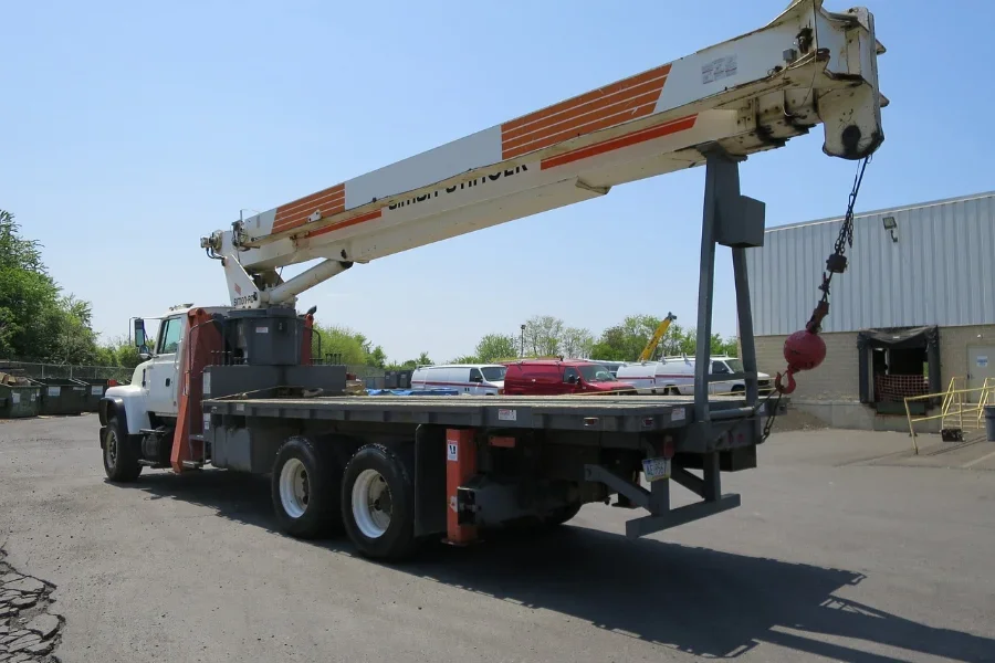 A white and red idle boom truck