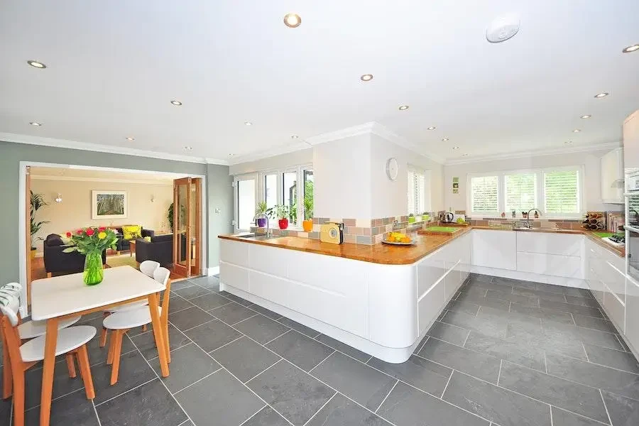 An all-white kitchen with concrete-effect floor tiles