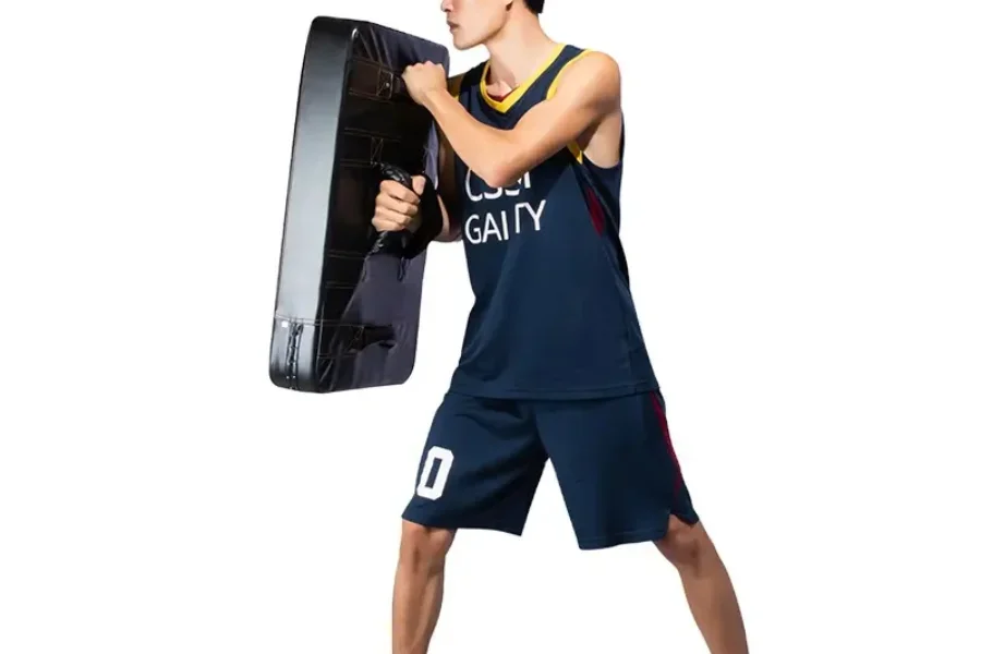 Jugador de baloncesto sosteniendo una gran almohadilla de bloqueo negra