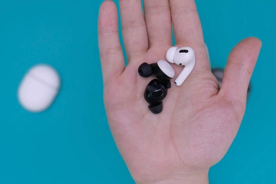 different brands of in ear headphones resting on a person's hand