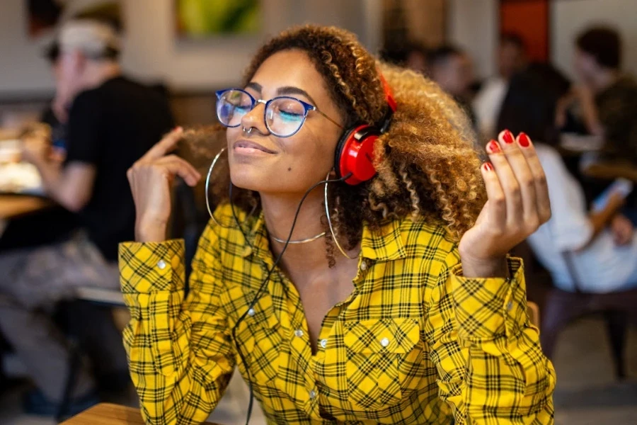 person wearing over ear headphones in a coffee shop