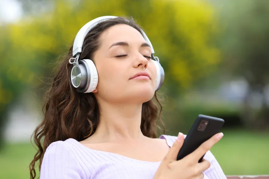 woman with white headphones listening to music