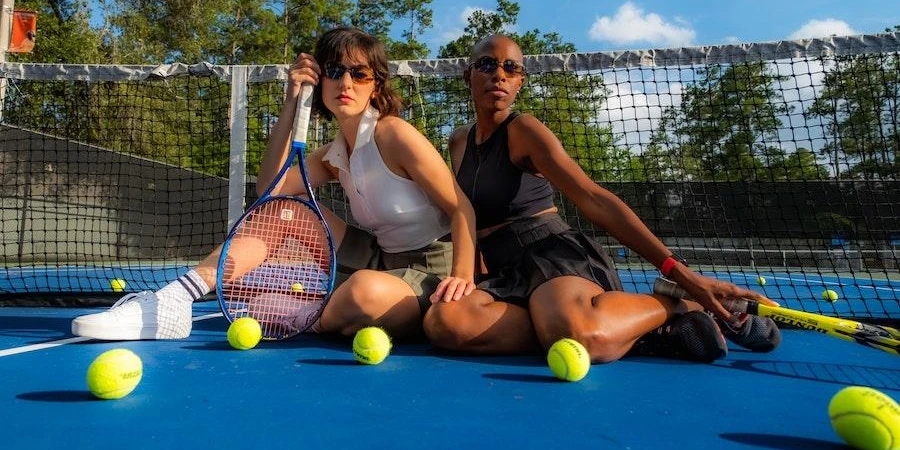 Women wearing country club outfits on tennis court