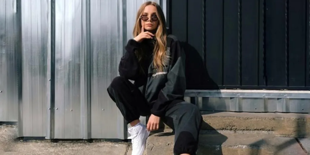 A lady in black sweatpants and cardigan with white sneakers