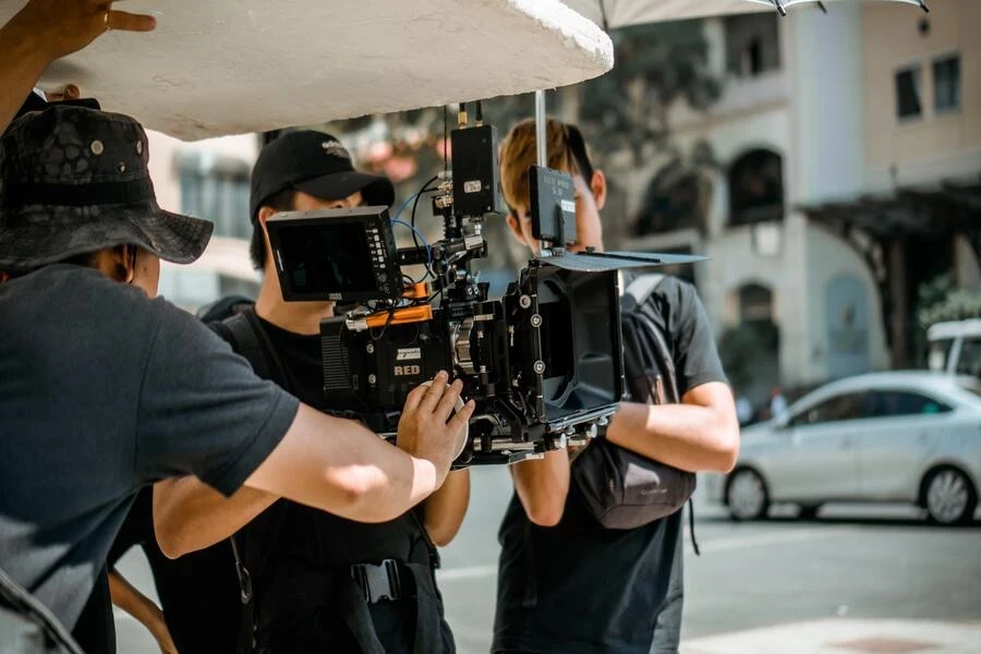 A man in a vest holding a camera