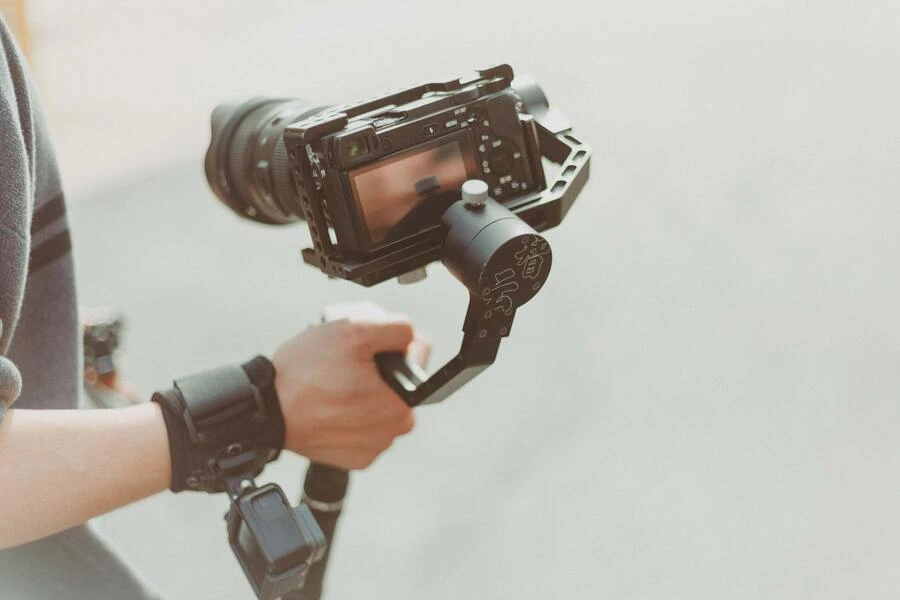 A person holding camera with an X-grip stabilizer