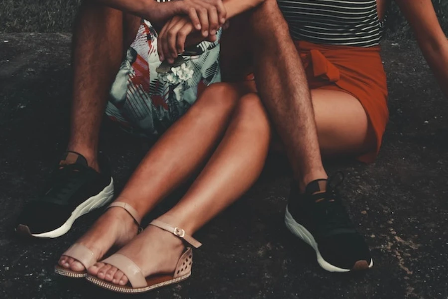 A woman and man sitting on the pavement