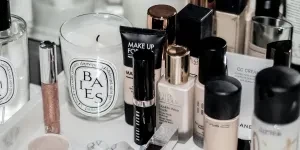 Assorted beauty products and brushes on a white table