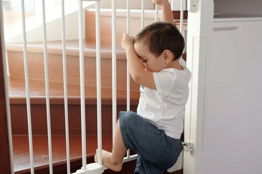 Baby trying to climb up a safety gate