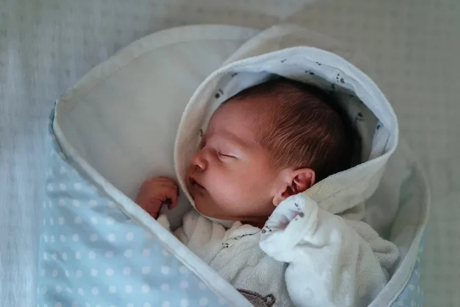 Bébé enveloppé dans une couverture blanche et bleue