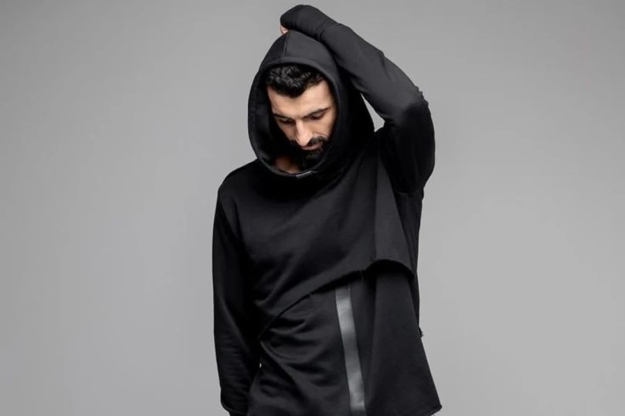Bearded man posing in black steampunk-inspired hoodie