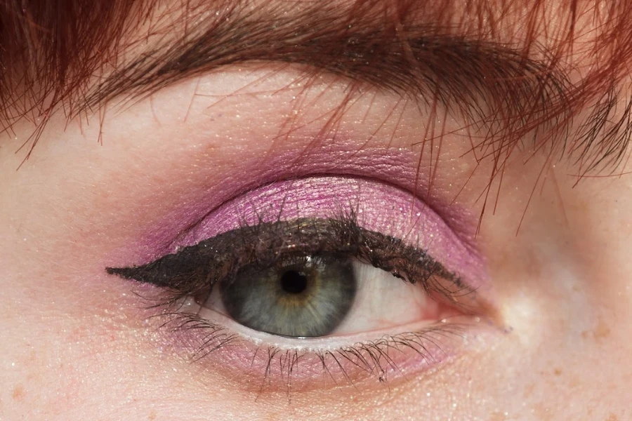 Close-up of a person’s eye wearing eyeliner and purple eye shadow