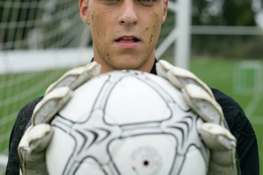 portero sosteniendo un balón de fútbol