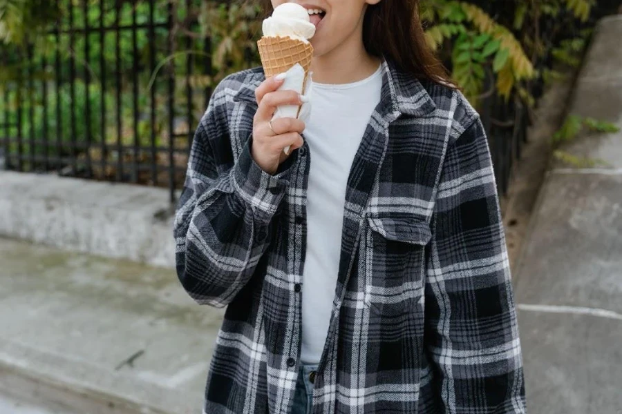 Señora disfrutando de un helado con una camisa de franela de gran tamaño