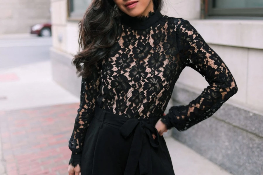 Lady wearing a black lace blouse striking a pose