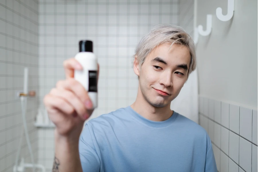 man holding a bottle of cleanser in the shower