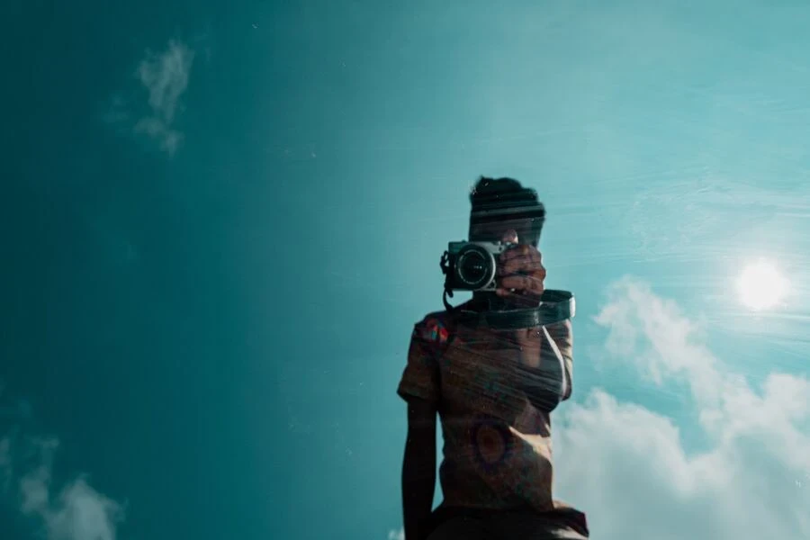 homem de jaqueta preta usando uma DSLR