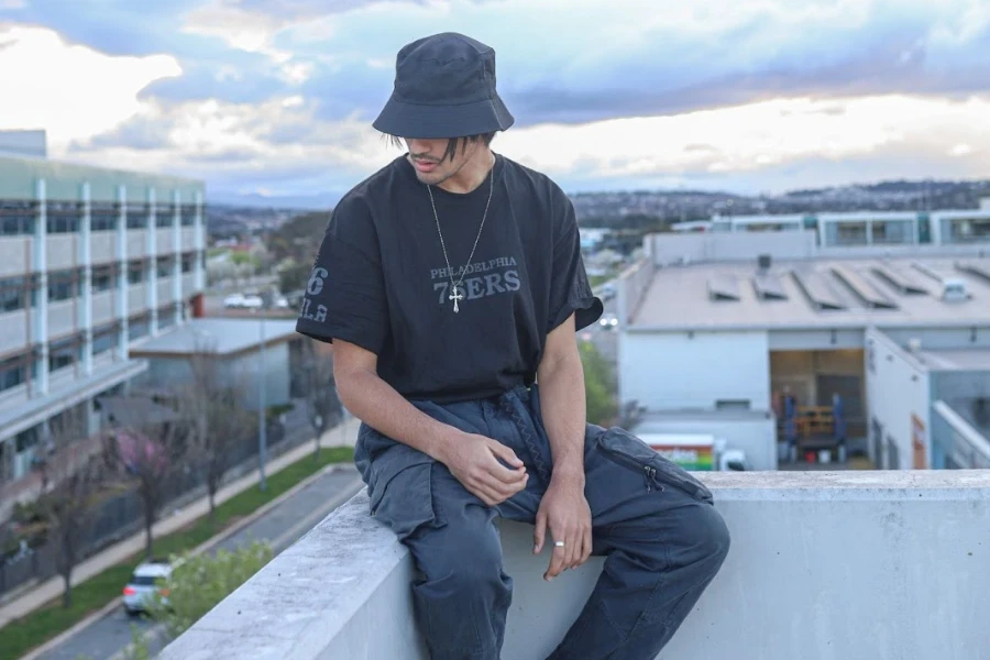 Man in cargo pants sitting on a high wall