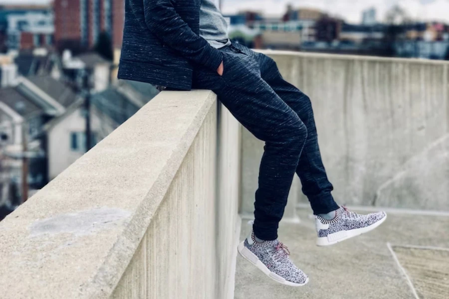 Man in classic joggers sitting on a ledge