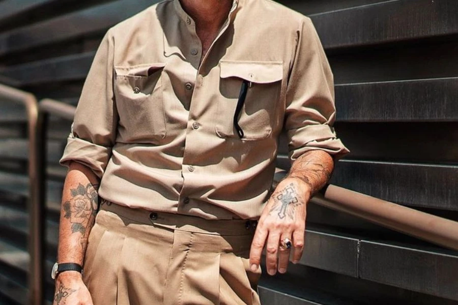 Man in safari shirt and khaki pants resting on railings