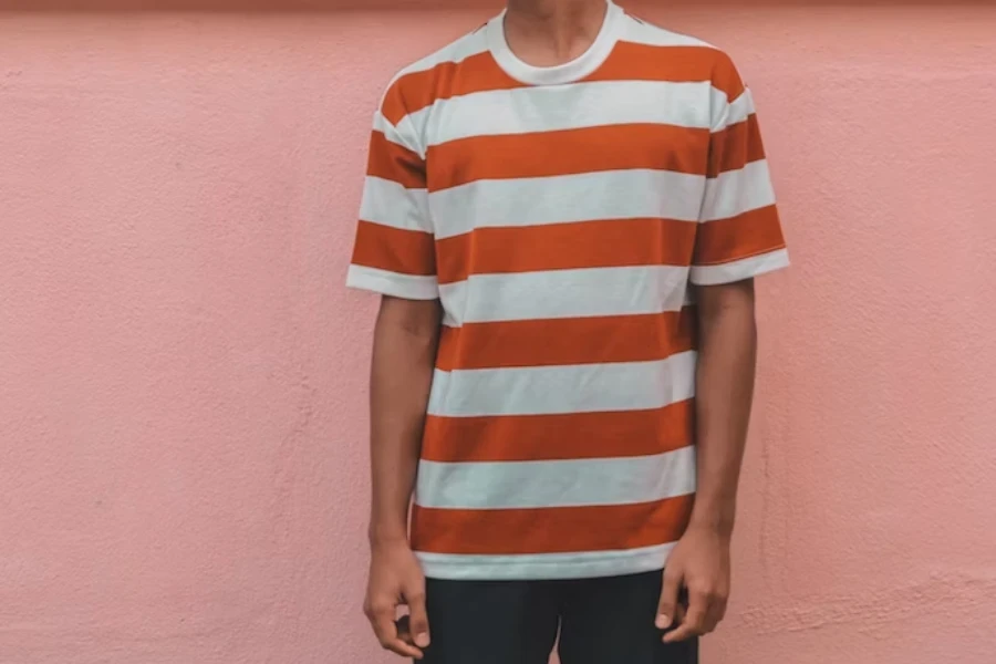 Homem posando em uma camiseta listrada branca e vermelha