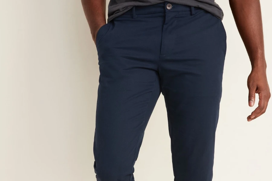 Man posing in blue slim-straight trousers