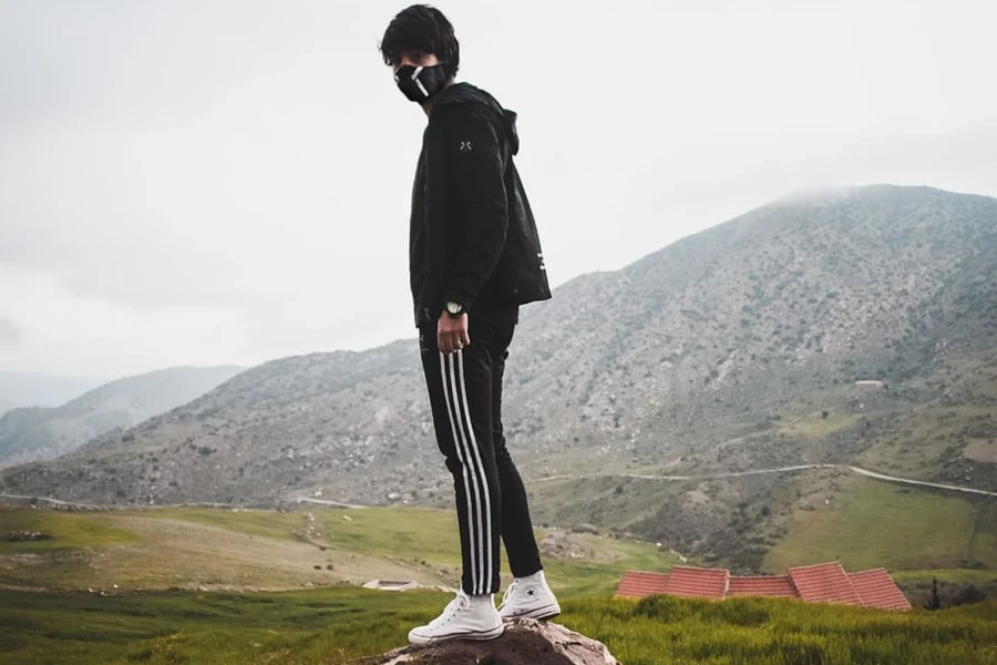 Man posing playfully in black track joggers